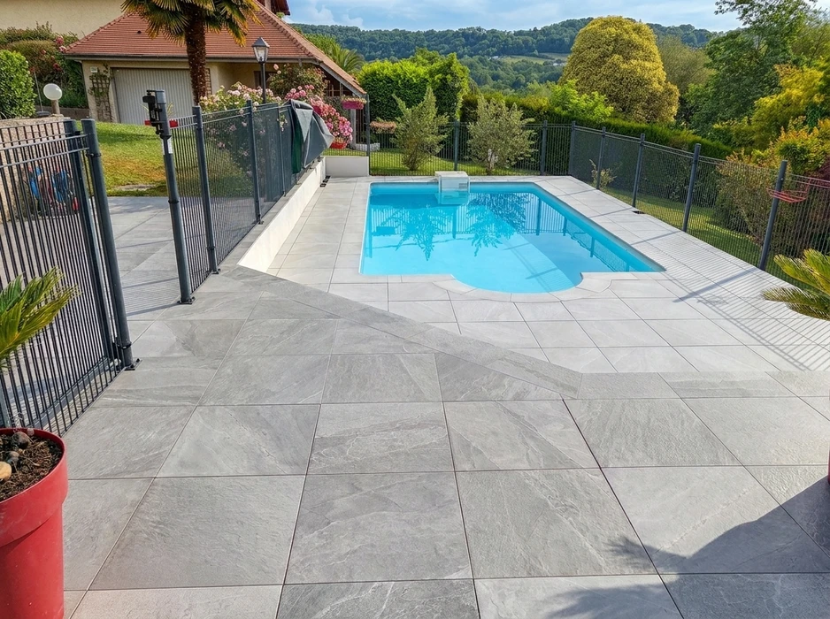 Terrasse extérieure en carrelage grand format grès cérame effet pierre naturelle, coloris gris clair, pose à joints réguliers