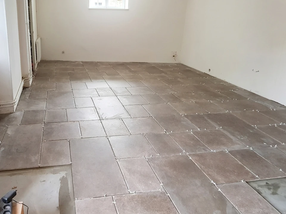 Pièce vide en cours de rénovation, carrelage de sol en cours de pose