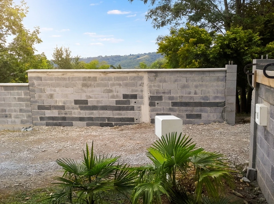 Construction d'un garage en parpaings, dalle béton fraîche, linteau en cours de séchage