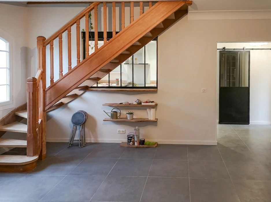 Entrée de maison rénovée avec escalier quart-tournant en bois massif (hêtre teinté), balustres tournés, limon apparent